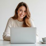 photo of woman smiling while using a laptop